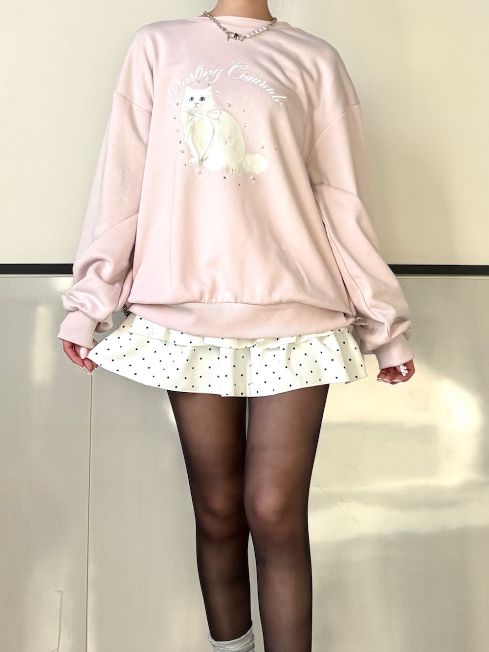 ピンク系のTシャツ/カットソー、ホワイト系のスカートを着用したレディースの冬コーディネートの2枚目の写真