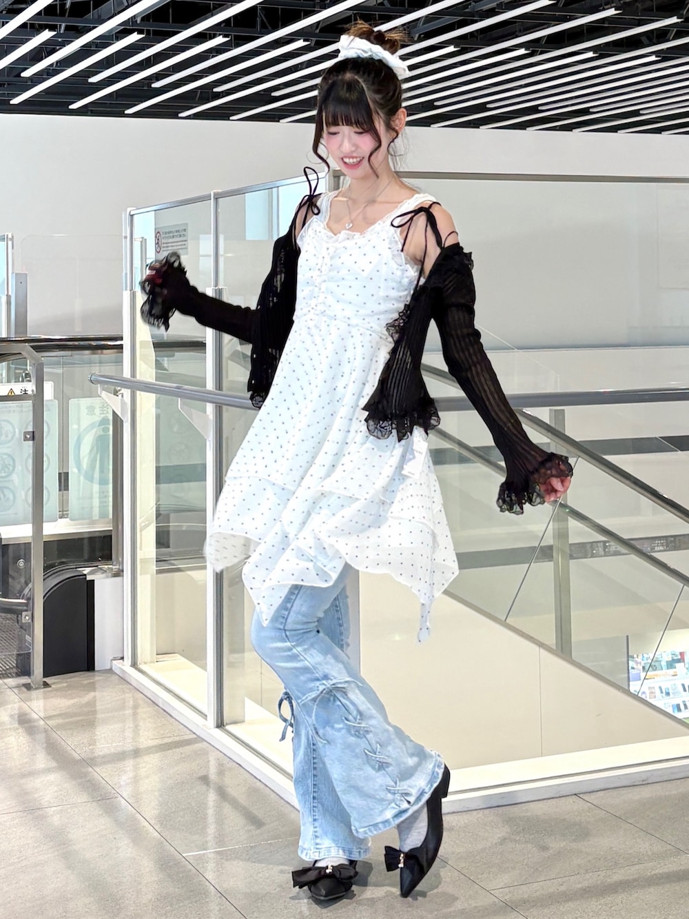 ブラック系のカーディガン/ボレロ、ホワイト系のワンピース、ブラック系のパンプスを着用したレディースの春コーディネートの3枚目の写真