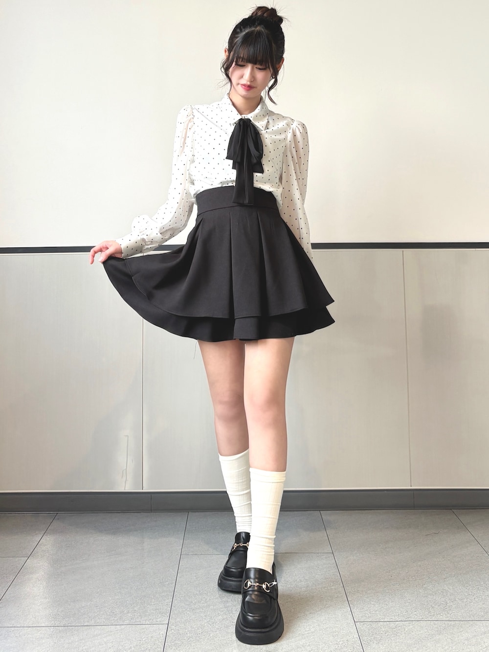 ホワイト系のシャツ/ブラウス、ブラック系のスカート、ブラック系のパンプスを着用したレディースの春コーディネートの2枚目の写真