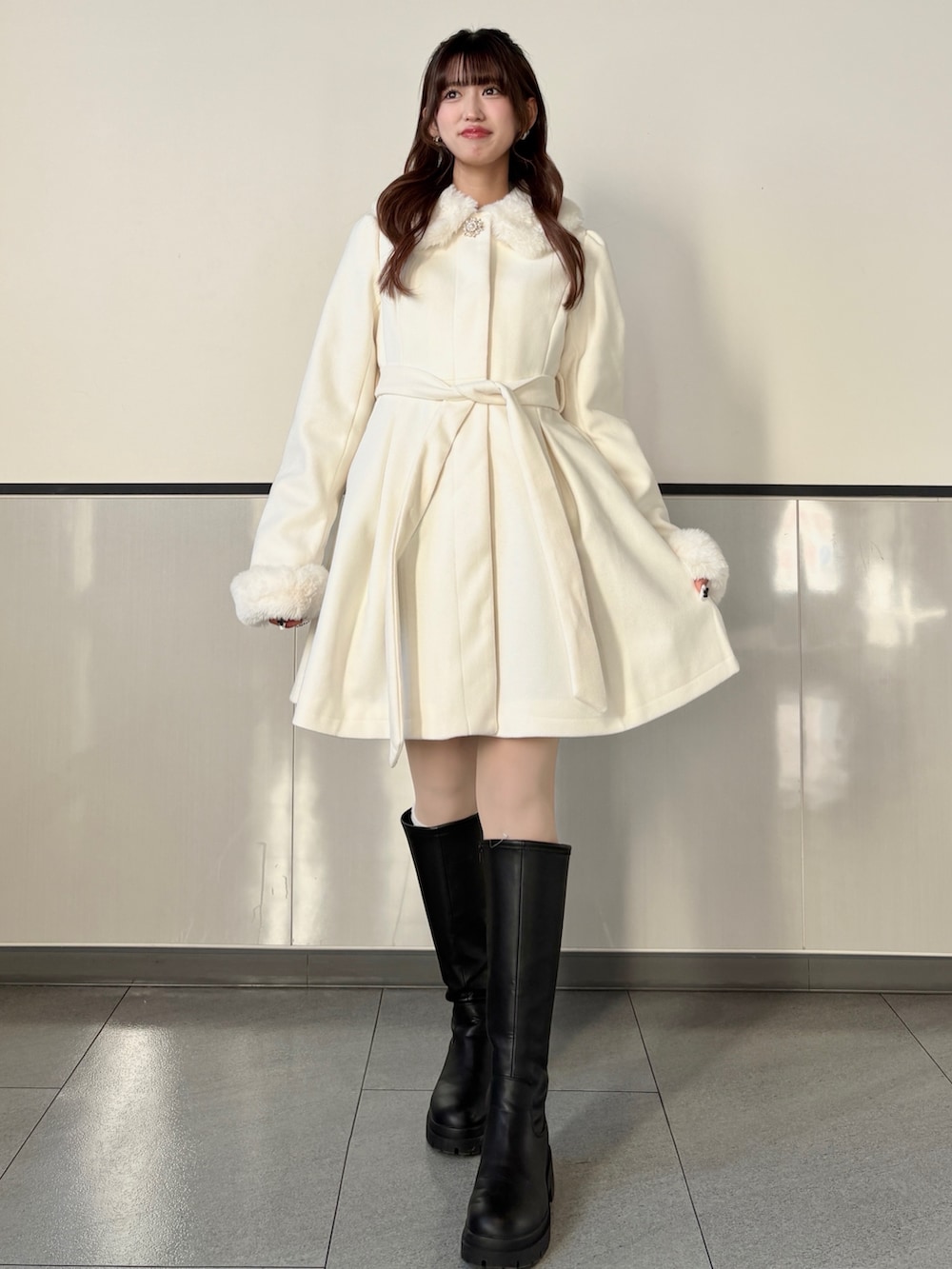 ホワイト系のその他アウター、ブラック系のブーツを着用したレディースの冬コーディネートの4枚目の写真