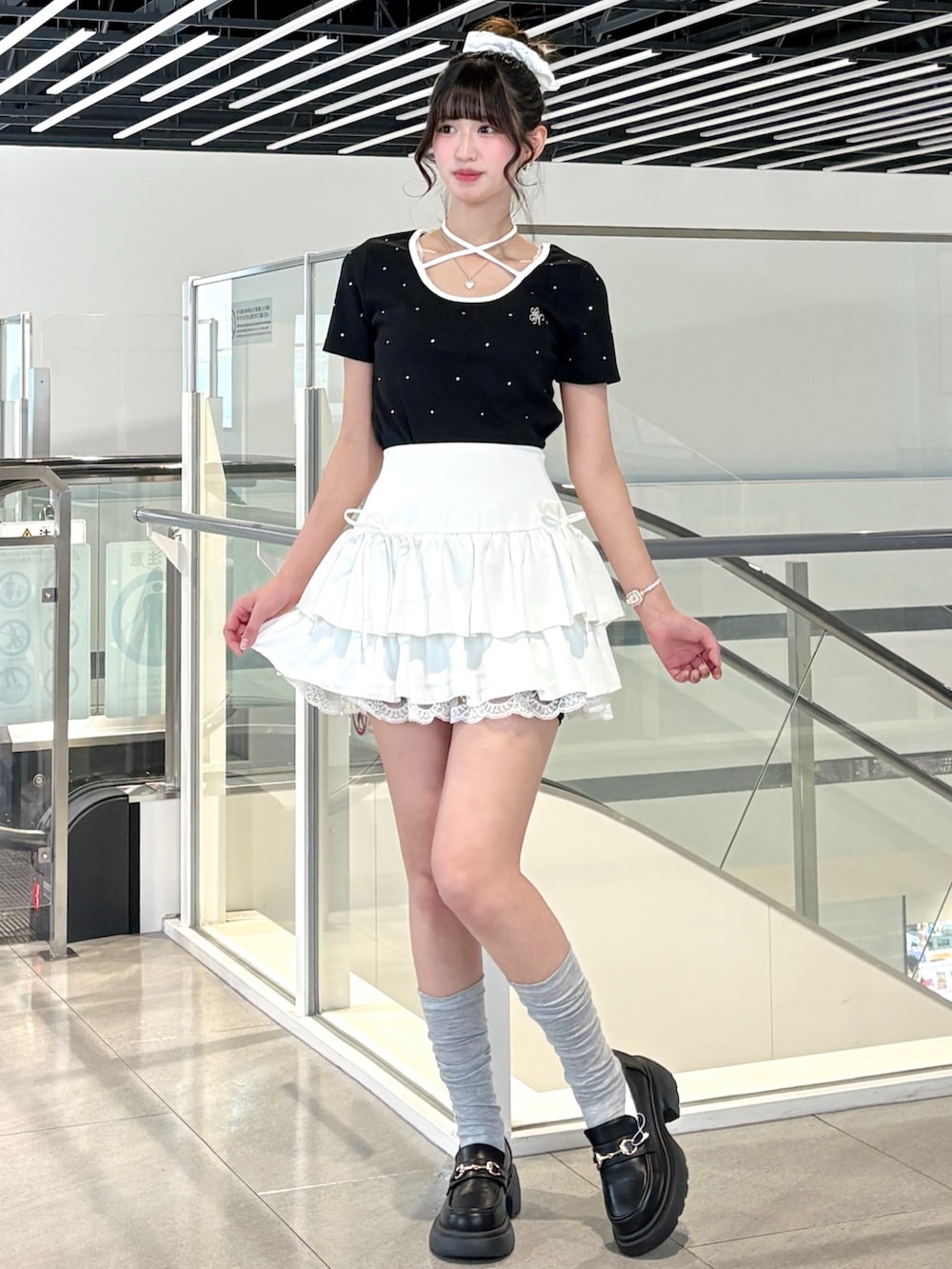 ブラック系のTシャツ/カットソー、ブラック系のパンプス、ホワイト系のスカートを着用したレディースの春コーディネートの2枚目の写真