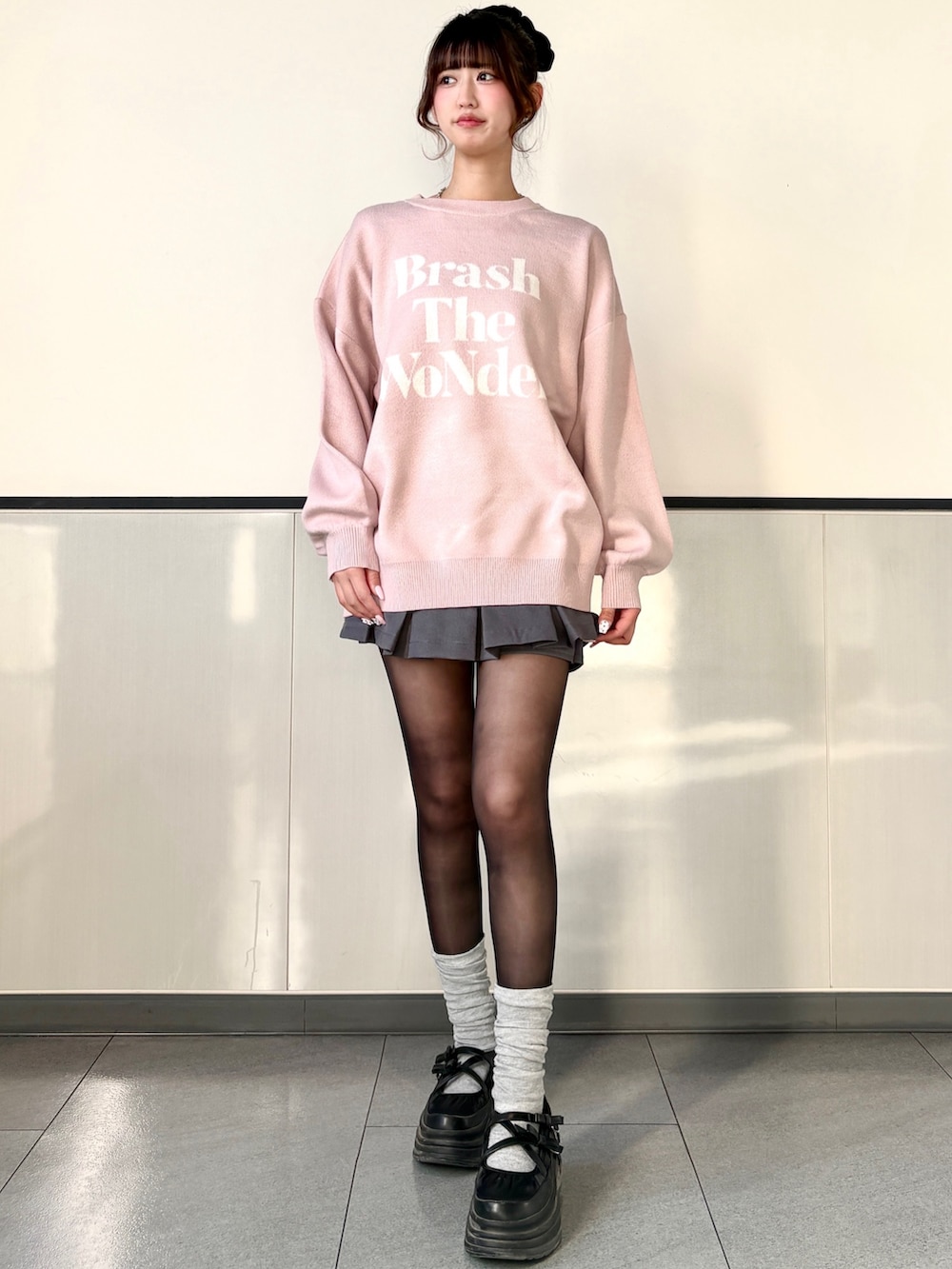 ピンク系のニット/セーター、グレー系のスカートを着用したレディースの冬コーディネートの2枚目の写真