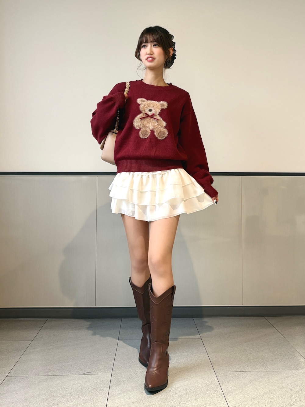 ホワイト系のスカート、ブラウン系のブーツ、ベージュ系のショルダーバッグを着用したレディースの秋コーディネートの2枚目の写真