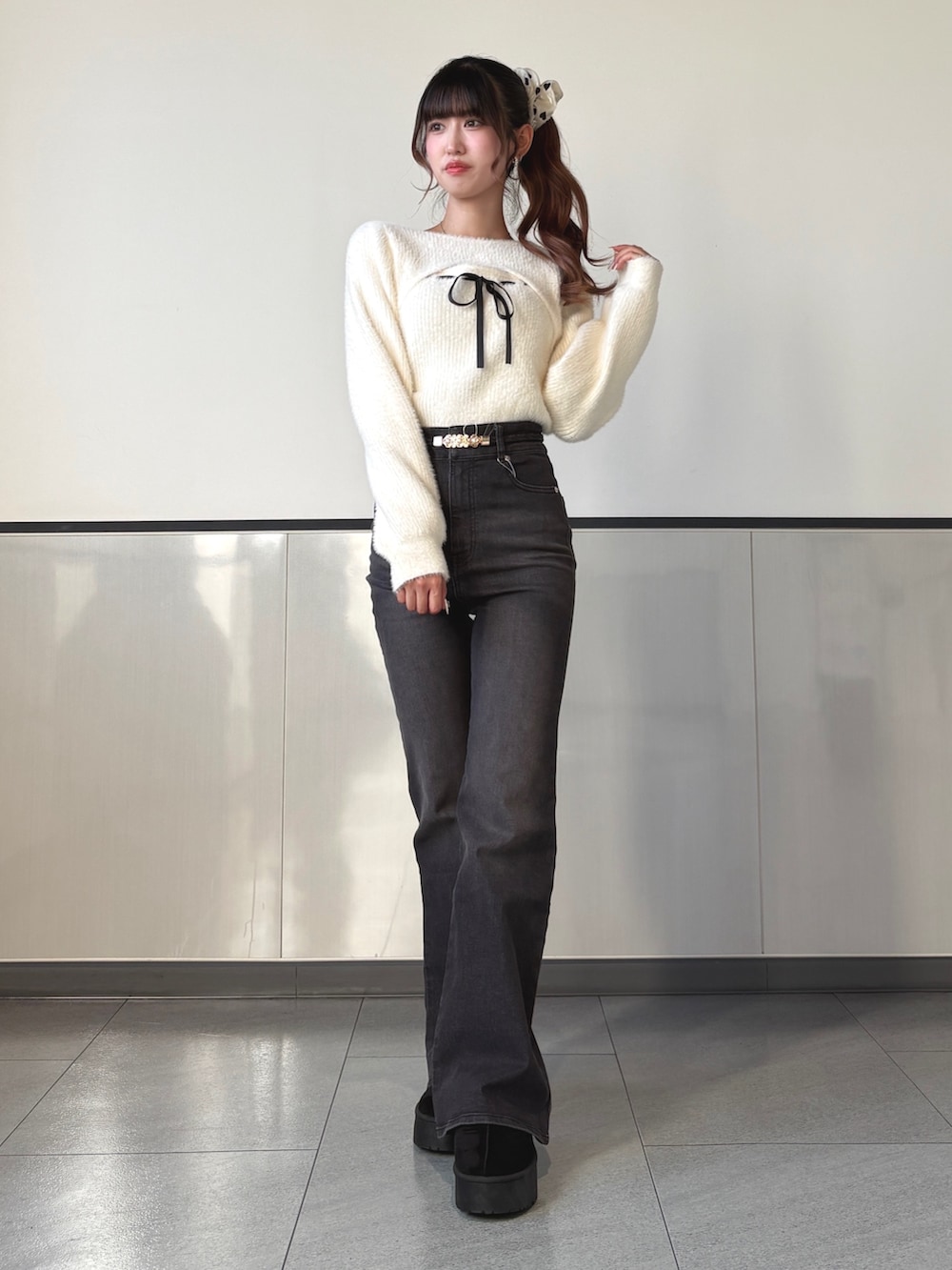 ホワイト系のニット/セーター、グレー系のデニムパンツ、ブラック系のハンドバッグを着用したレディースの秋コーディネートの2枚目の写真