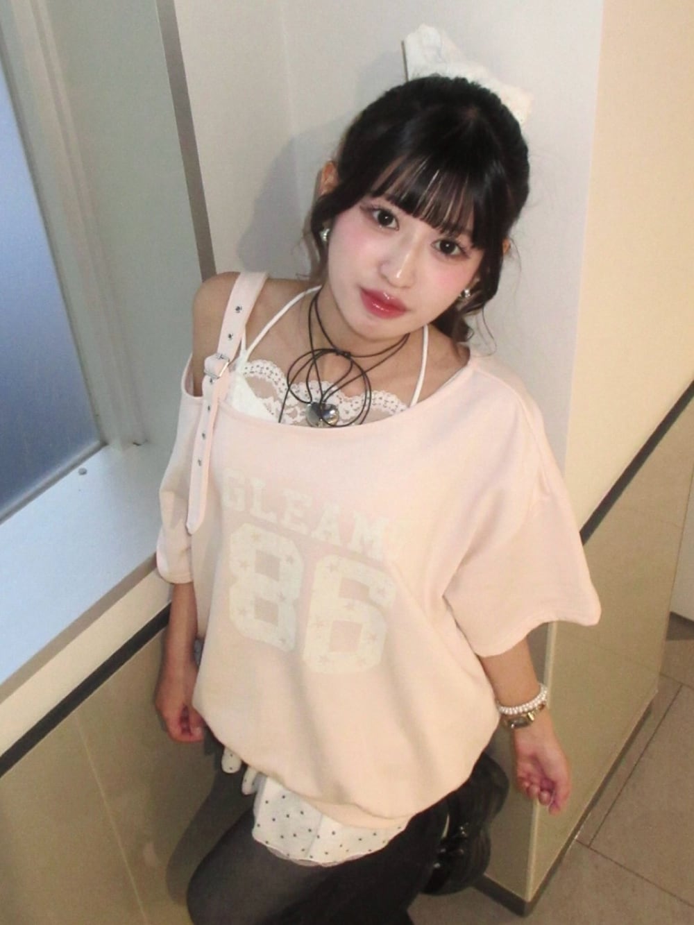 ピンク系のTシャツ/カットソー、ホワイト系のスカート、ブラック系のデニムパンツを着用したレディースの春コーディネートの2枚目の写真
