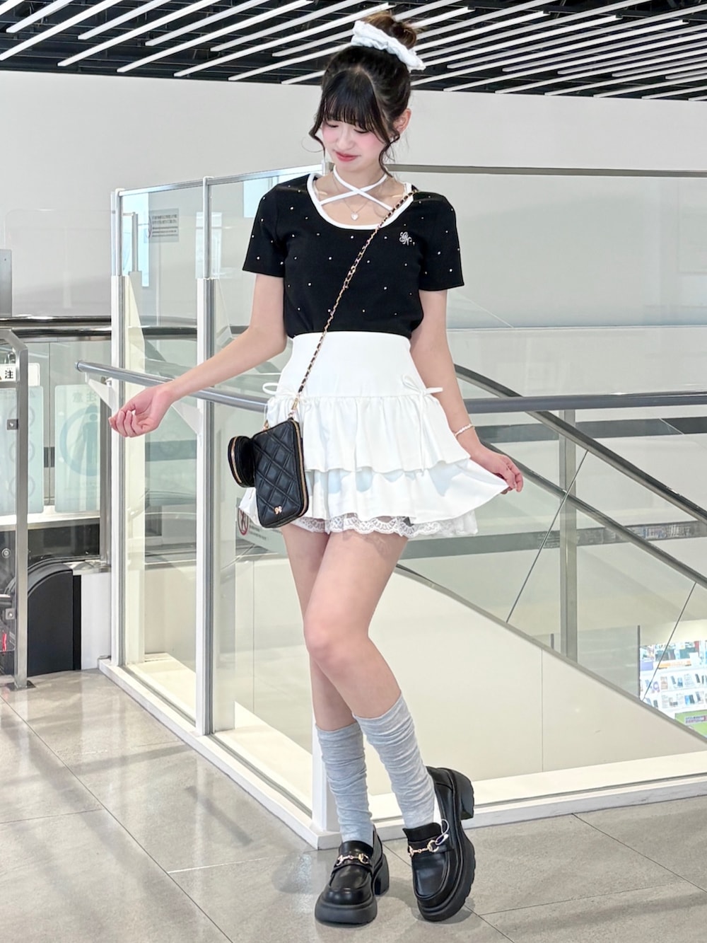 ブラック系のTシャツ/カットソー、ブラック系のパンプス、ホワイト系のスカートを着用したレディースの春コーディネートの3枚目の写真