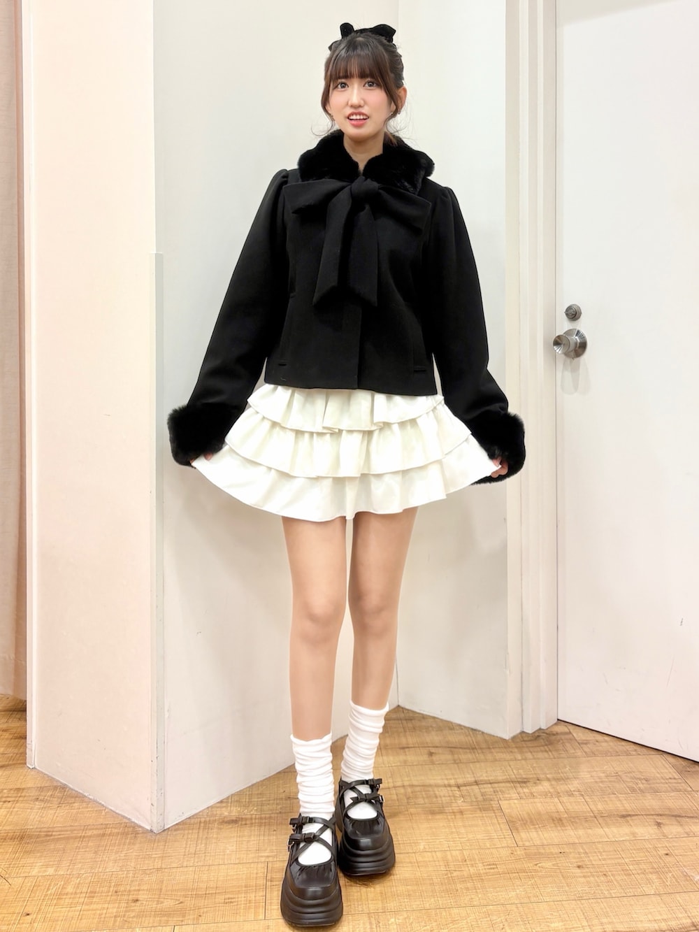 ブラック系のダウンジャケット/コート、ホワイト系のスカートを着用したレディースの冬コーディネートの2枚目の写真