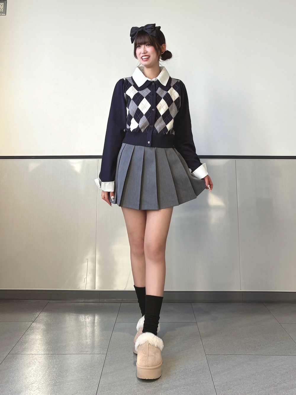 ブルー系のニット/セーター、グレー系のスカート、ベージュ系のブーツを着用したレディースの秋コーディネートの2枚目の写真