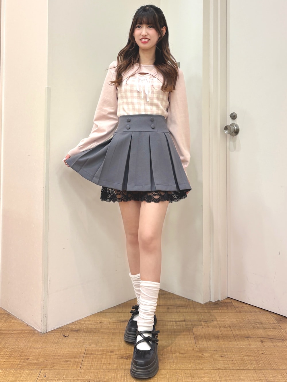 ホワイト系のニット/セーター、グレー系のスカートを着用したレディースの冬コーディネートの3枚目の写真