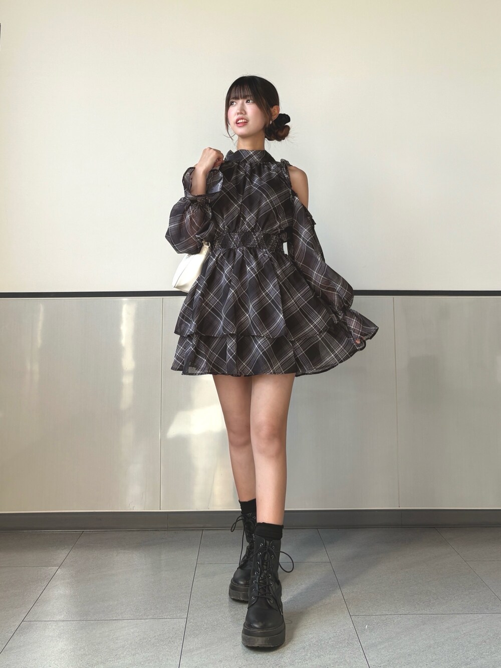 ブラック系のワンピース、ホワイト系のショルダーバッグを着用したレディースの秋コーディネートの2枚目の写真