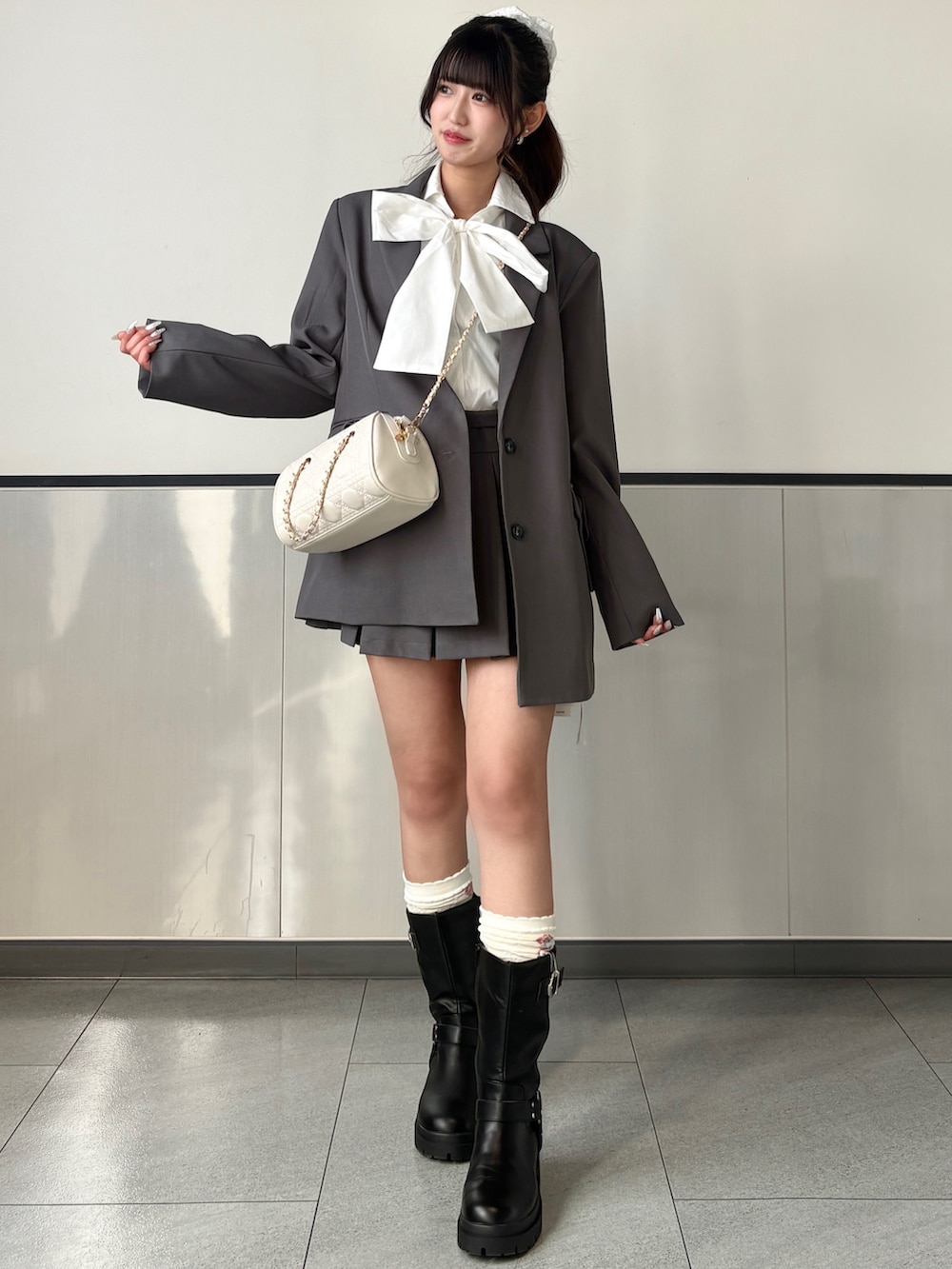 グレー系のテーラードジャケット、グレー系のスカート、ホワイト系のシャツ/ブラウスを着用したレディースの春コーディネートの2枚目の写真