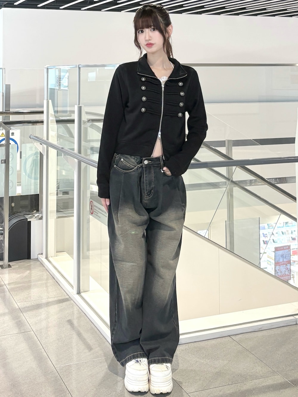 ブラック系のスウェット、ブルー系のデニムパンツを着用したレディースの秋コーディネートの2枚目の写真