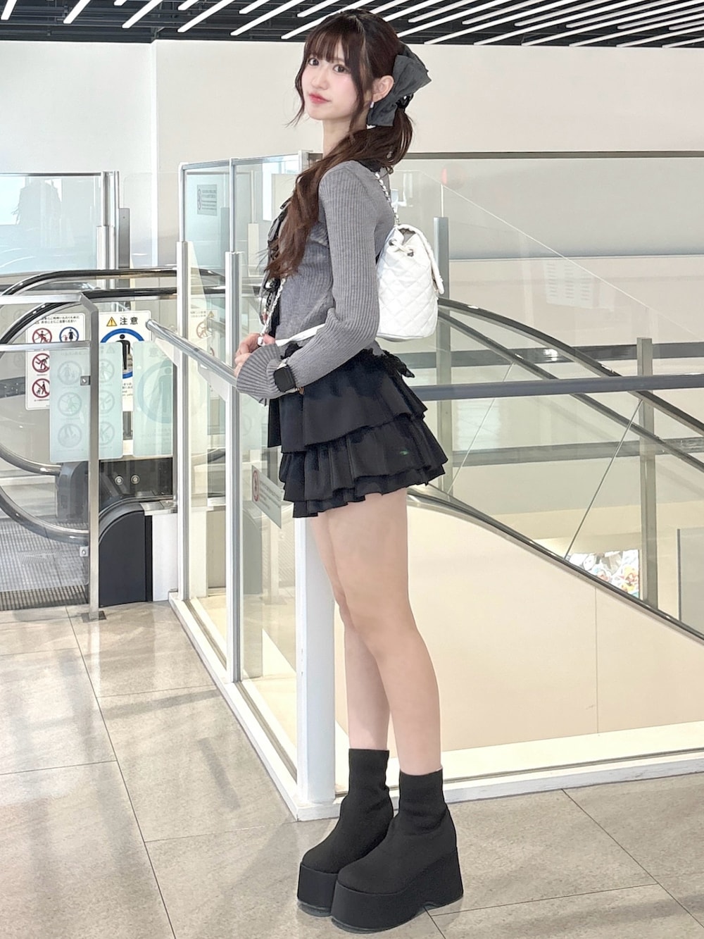 グレー系のカーディガン/ボレロ、ブラック系のスカート、ブラック系のブーツを着用したレディースの秋コーディネートの3枚目の写真