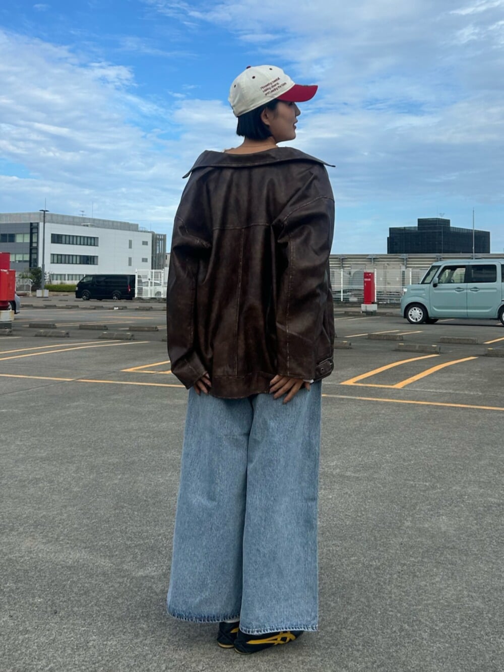 ブルー系のデニムパンツ、ブラウン系のブルゾン、ホワイト系のシャツ/ブラウスを着用したレディースの秋コーディネートの3枚目の写真