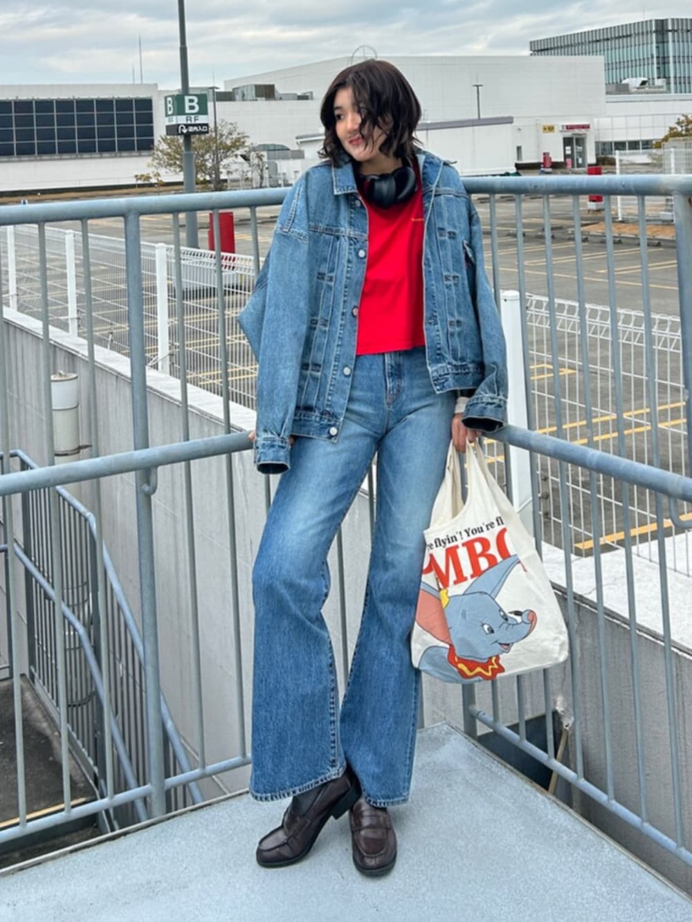 ブルー系のデニムパンツ、ブルー系のデニムジャケット、レッド系のTシャツ/カットソーを着用したレディースの冬コーディネートの4枚目の写真