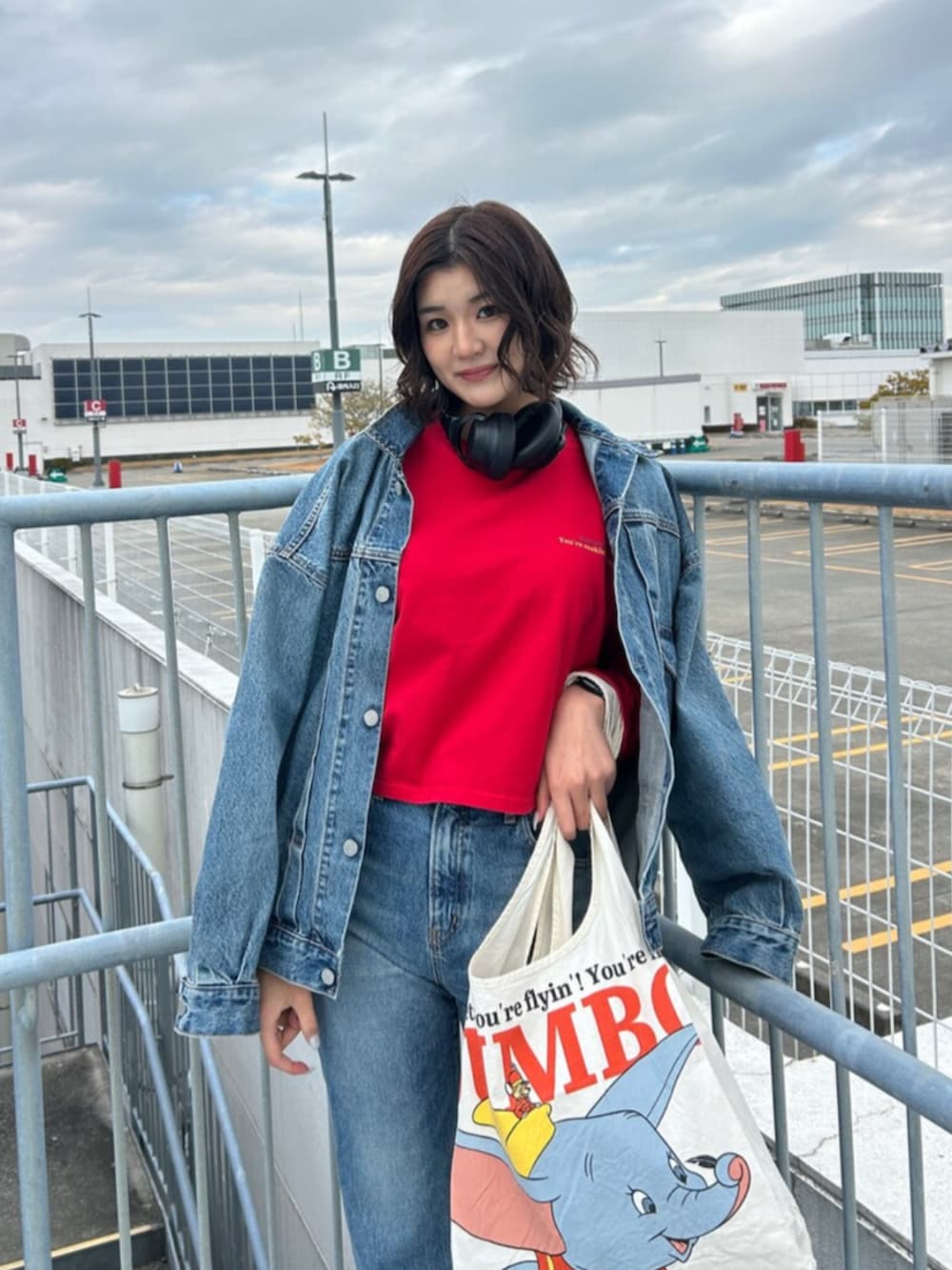 ブルー系のデニムパンツ、ブルー系のデニムジャケット、レッド系のTシャツ/カットソーを着用したレディースの冬コーディネートの7枚目の写真