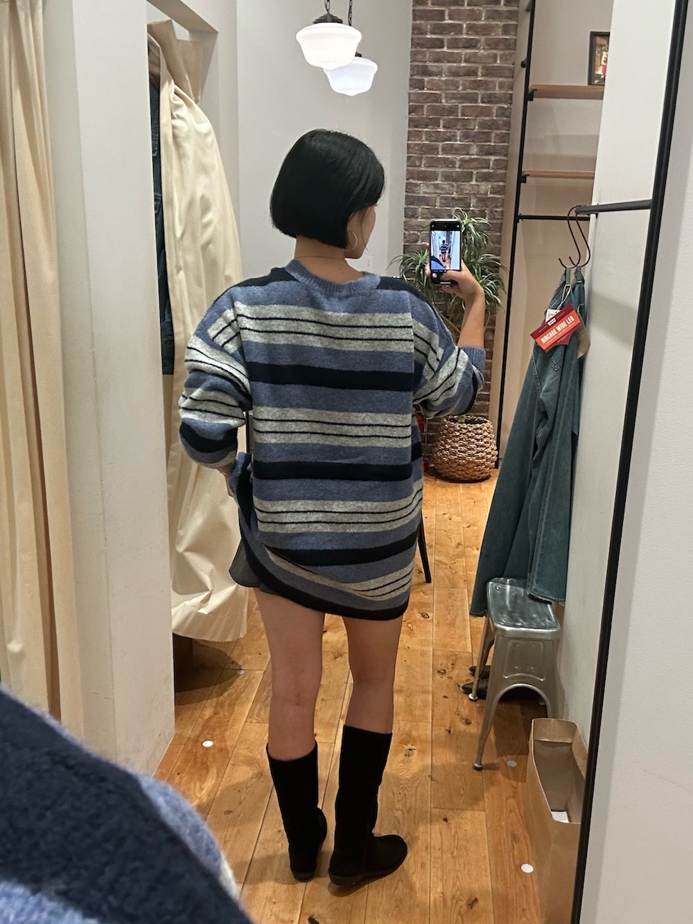 ブルー系のニット/セーター、ブラック系のブーツ、ブルー系のマフラーを着用したレディースの秋コーディネートの4枚目の写真