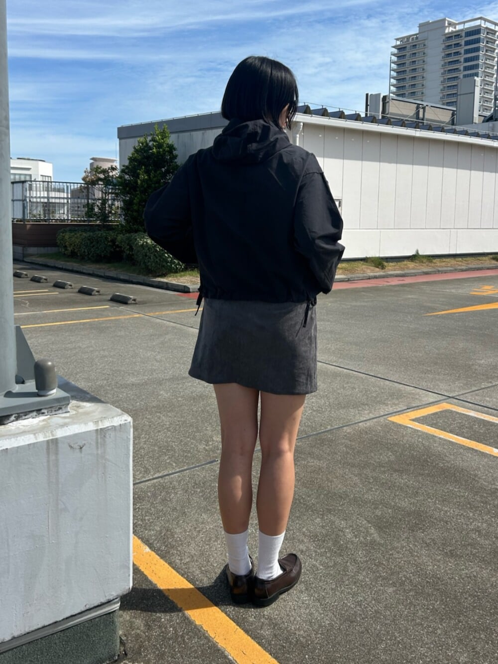 グレー系のスカート、ブラック系のパーカーを着用したレディースの秋コーディネートの3枚目の写真