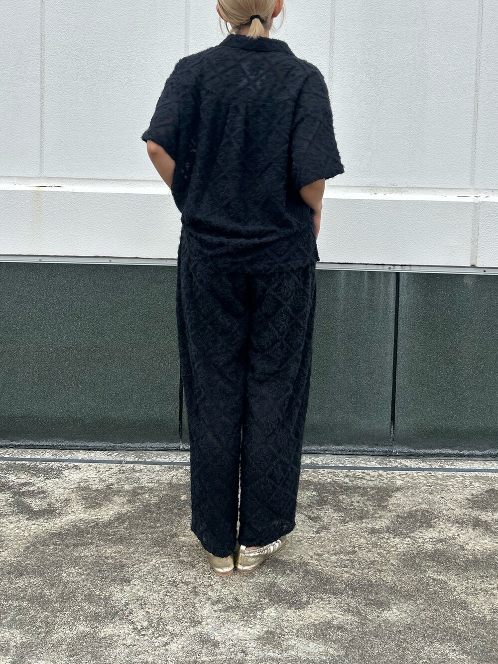 ブラック系のシャツ/ブラウス、ブラック系のその他パンツ、ゴールド系のバレエシューズを着用したレディースの夏コーディネートの3枚目の写真