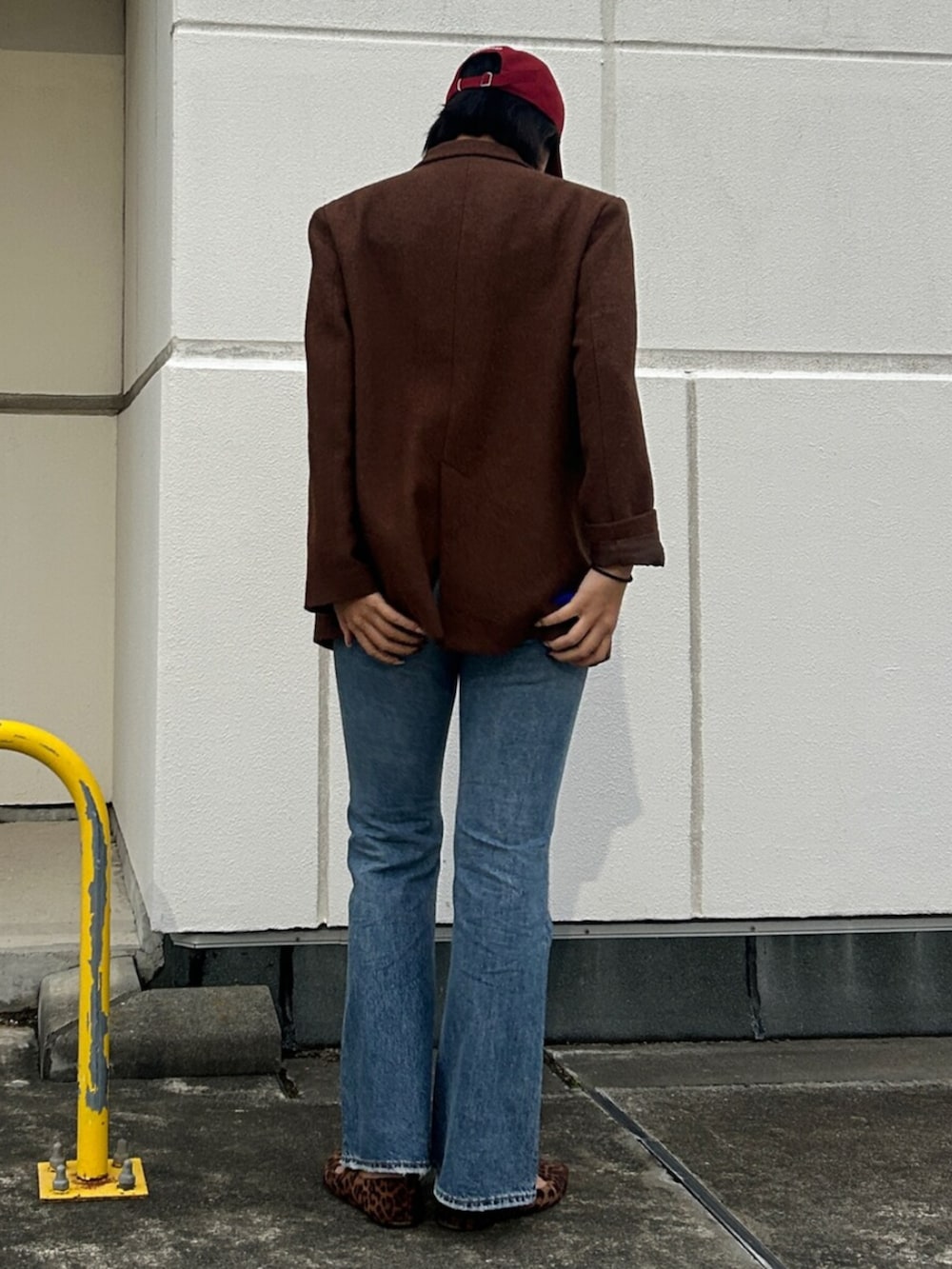 ブルー系のデニムパンツ、ブラウン系のテーラードジャケット、ホワイト系のキャミソールを着用したレディースの秋コーディネートの2枚目の写真