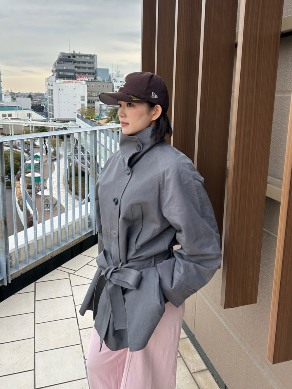 ブラック系のブーツ、ピンク系のスウェットパンツ、グレー系のトレンチコートを着用したレディースの冬コーディネートの4枚目の写真