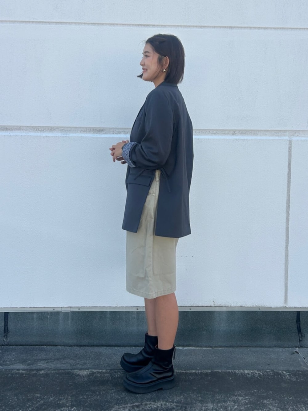 ベージュ系のデニムパンツ、グレー系のテーラードジャケット、レッド系のTシャツ/カットソーを着用したレディースの夏コーディネートの2枚目の写真