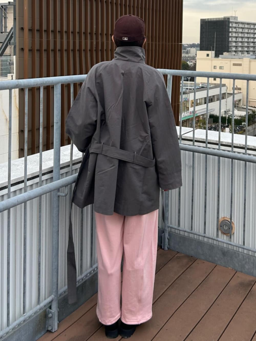 ブラック系のブーツ、ピンク系のスウェットパンツ、グレー系のトレンチコートを着用したレディースの冬コーディネートの2枚目の写真