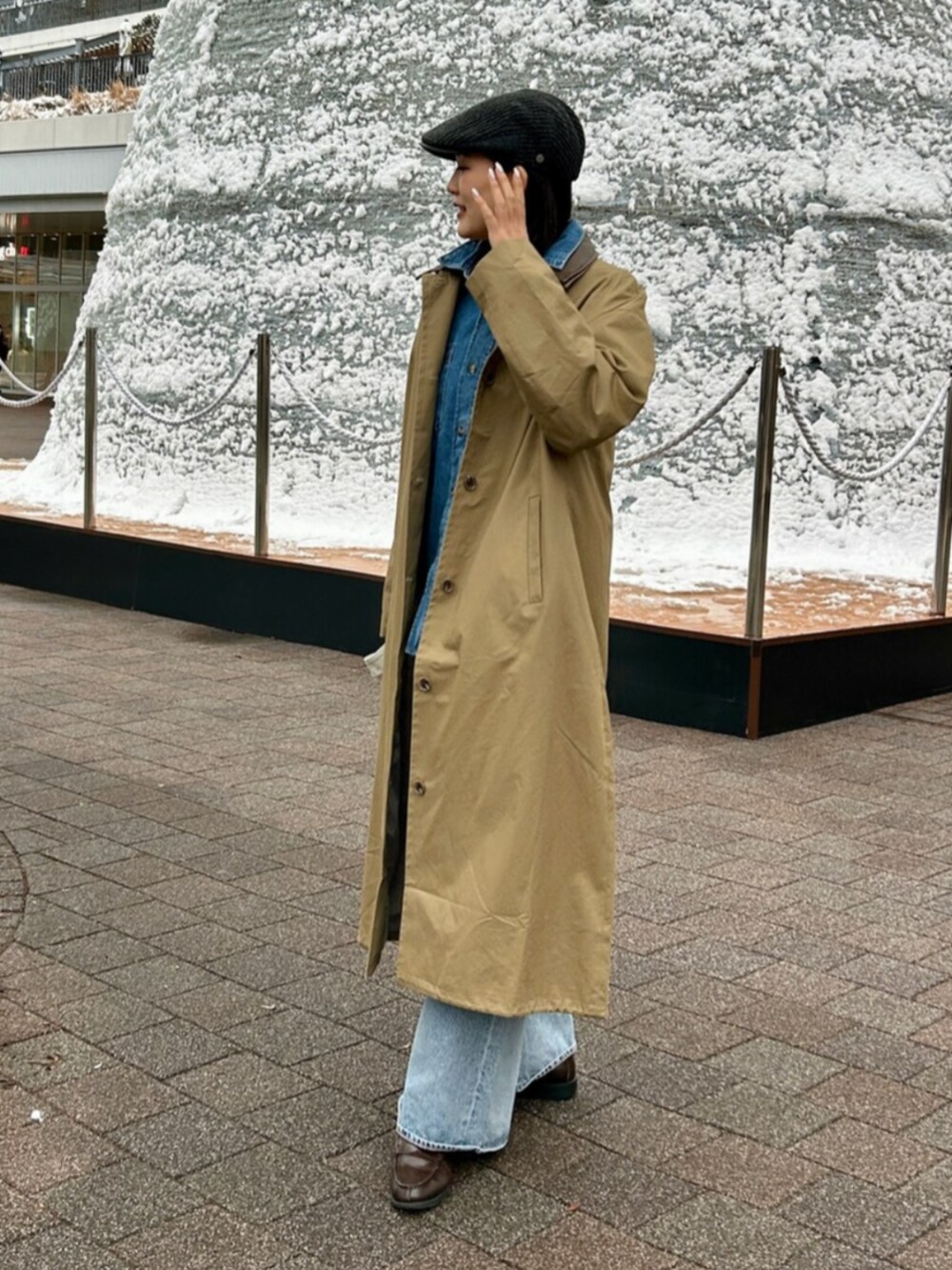 ブルー系のデニムパンツ、ブルー系のシャツ/ブラウス、ベージュ系のステンカラーコートを着用したレディースの冬コーディネートの2枚目の写真