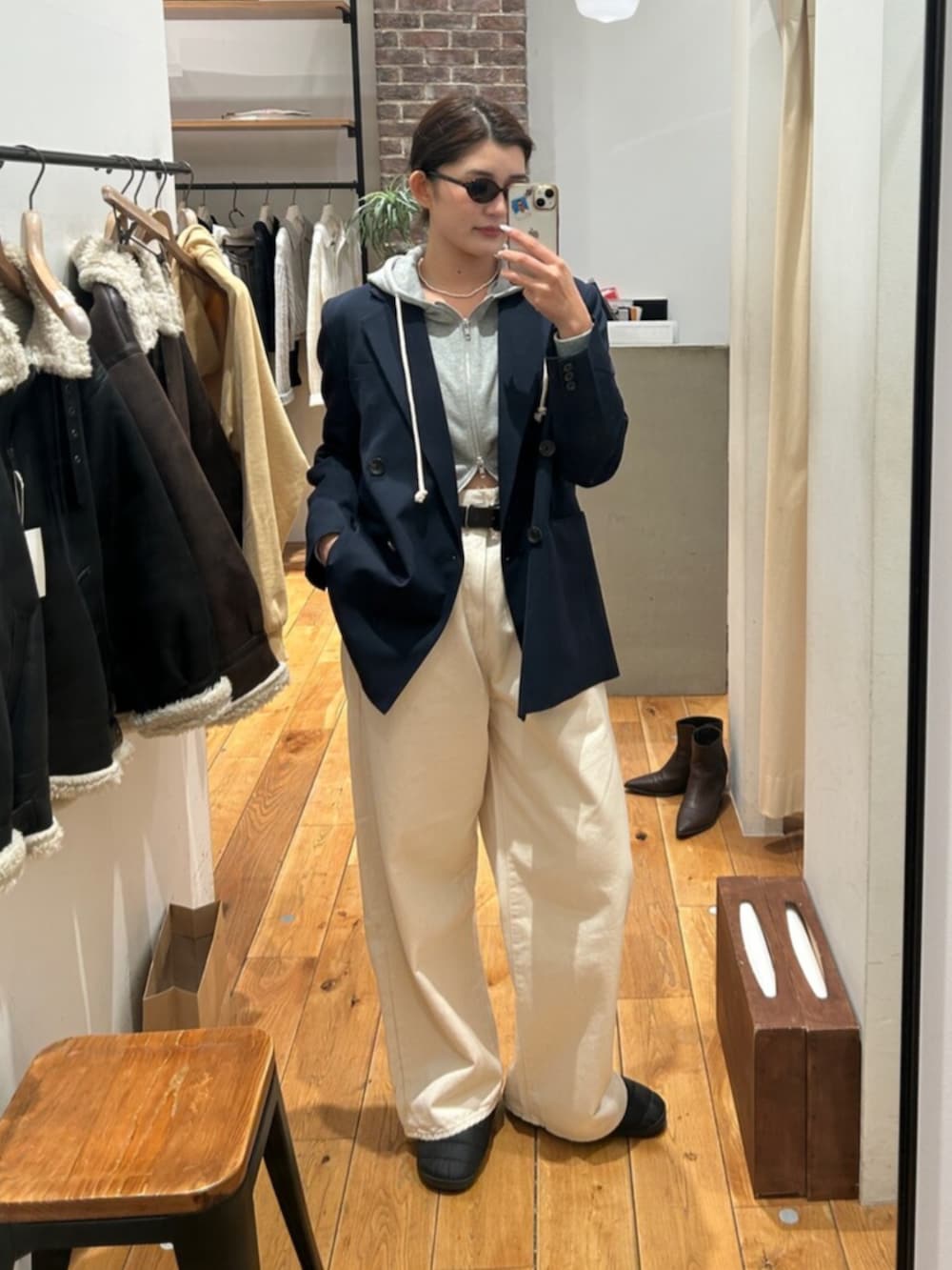 グレー系のパーカー、ブルー系のテーラードジャケット、ホワイト系のデニムパンツを着用したレディースの冬コーディネートの6枚目の写真