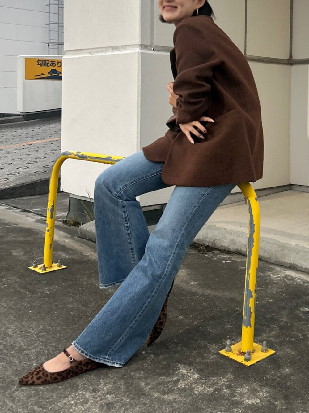 ブルー系のデニムパンツ、ブラウン系のテーラードジャケット、ホワイト系のキャミソールを着用したレディースの秋コーディネートの3枚目の写真