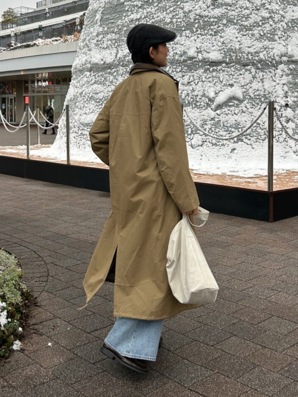 ブルー系のデニムパンツ、ブルー系のシャツ/ブラウス、ベージュ系のステンカラーコートを着用したレディースの冬コーディネートの4枚目の写真