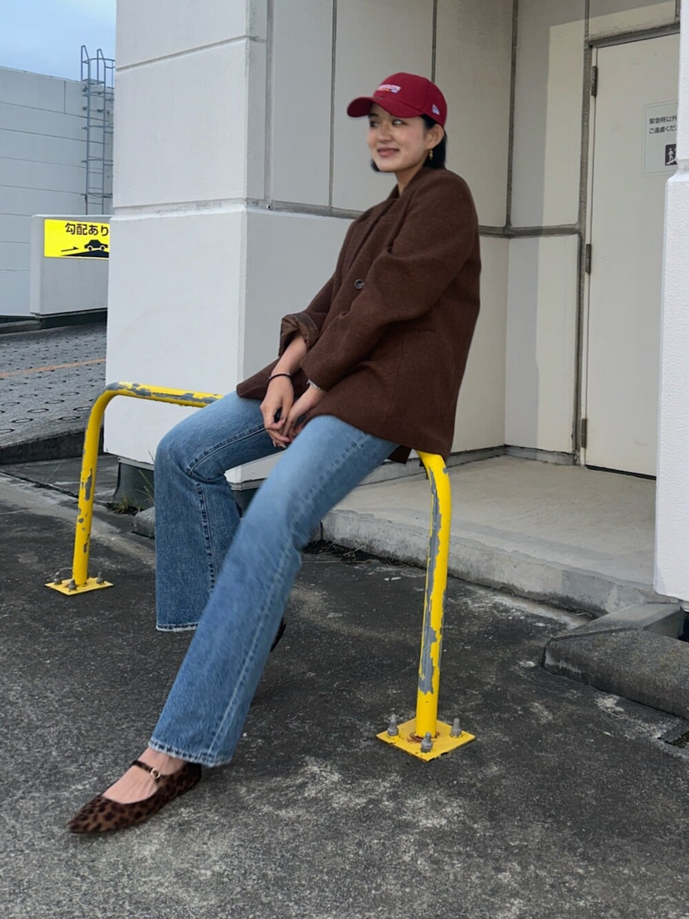 ブルー系のデニムパンツ、ブラウン系のテーラードジャケット、ホワイト系のキャミソールを着用したレディースの秋コーディネートの4枚目の写真