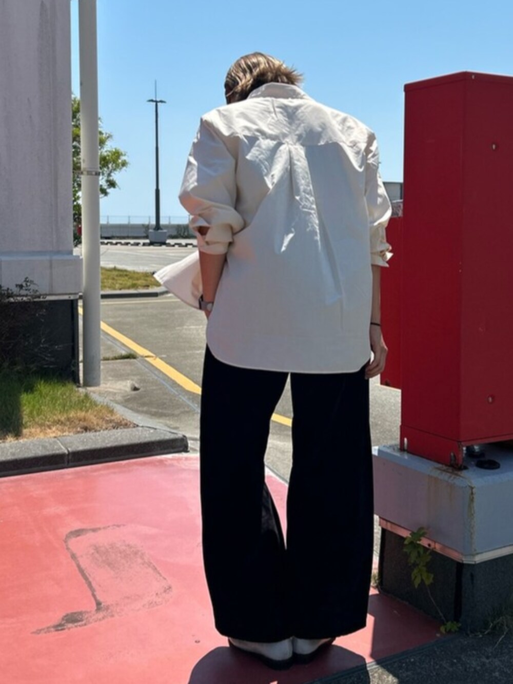 ブラック系のデニムパンツ、ベージュ系のシャツ/ブラウス、ベージュ系のローファーを着用したレディースの夏コーディネートの3枚目の写真