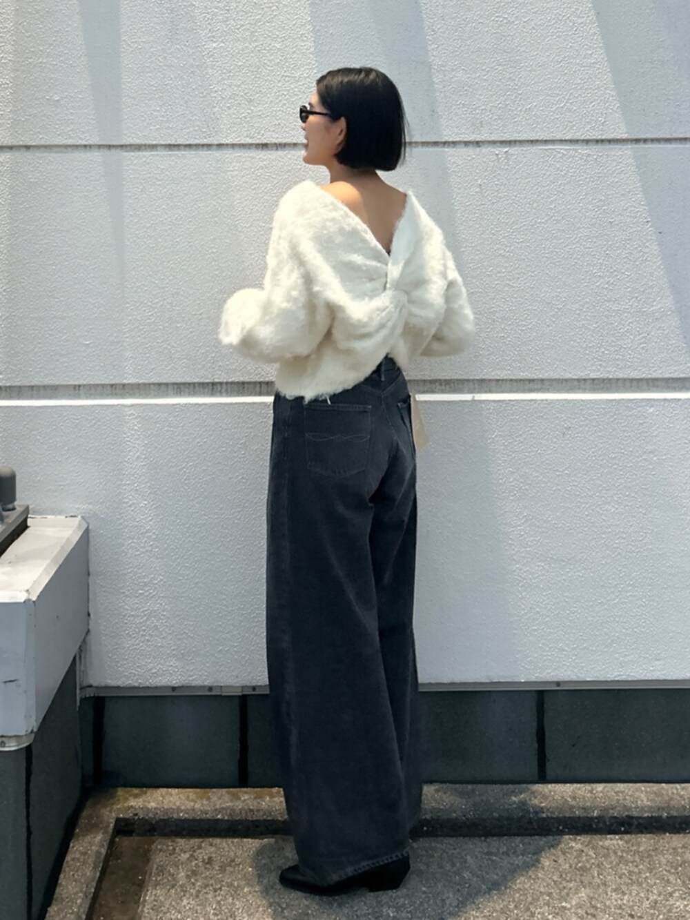 ホワイト系のニット/セーター、ブラック系のデニムパンツ、ブラック系のブーツを着用したレディースの秋コーディネートの3枚目の写真