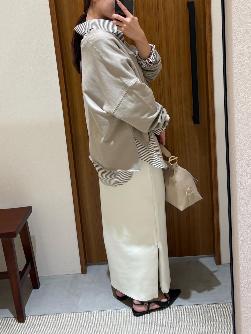 ホワイト系のスカート、ブラック系のパンプス、ベージュ系のハンドバッグを着用したレディースの春コーディネートの2枚目の写真
