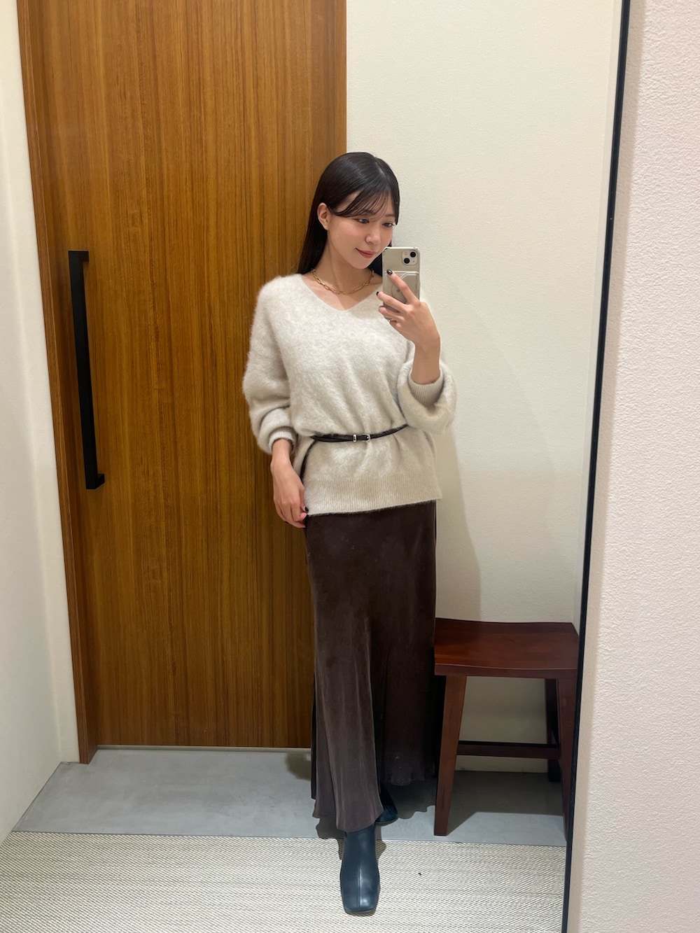 ホワイト系のニット/セーター、ホワイト系のハンドバッグ、ブラウン系のスカートを着用したレディースの冬コーディネートの3枚目の写真