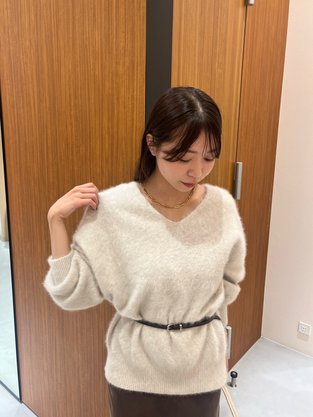 ホワイト系のニット/セーター、ホワイト系のハンドバッグ、ブラウン系のスカートを着用したレディースの冬コーディネートの5枚目の写真