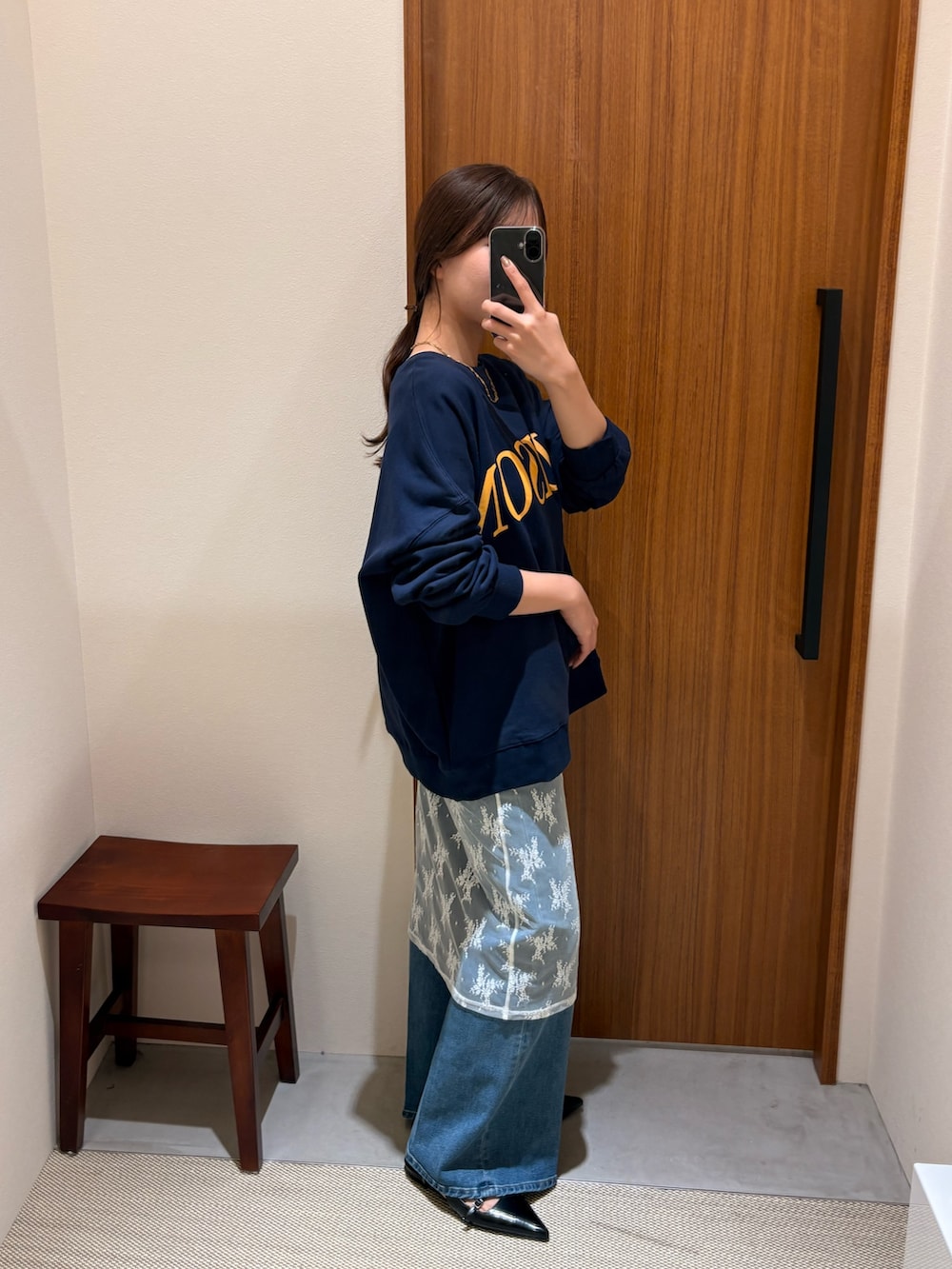 ブルー系のスウェット、ホワイト系のチュニック、ブラック系のパンプスを着用したレディースの冬コーディネートの2枚目の写真