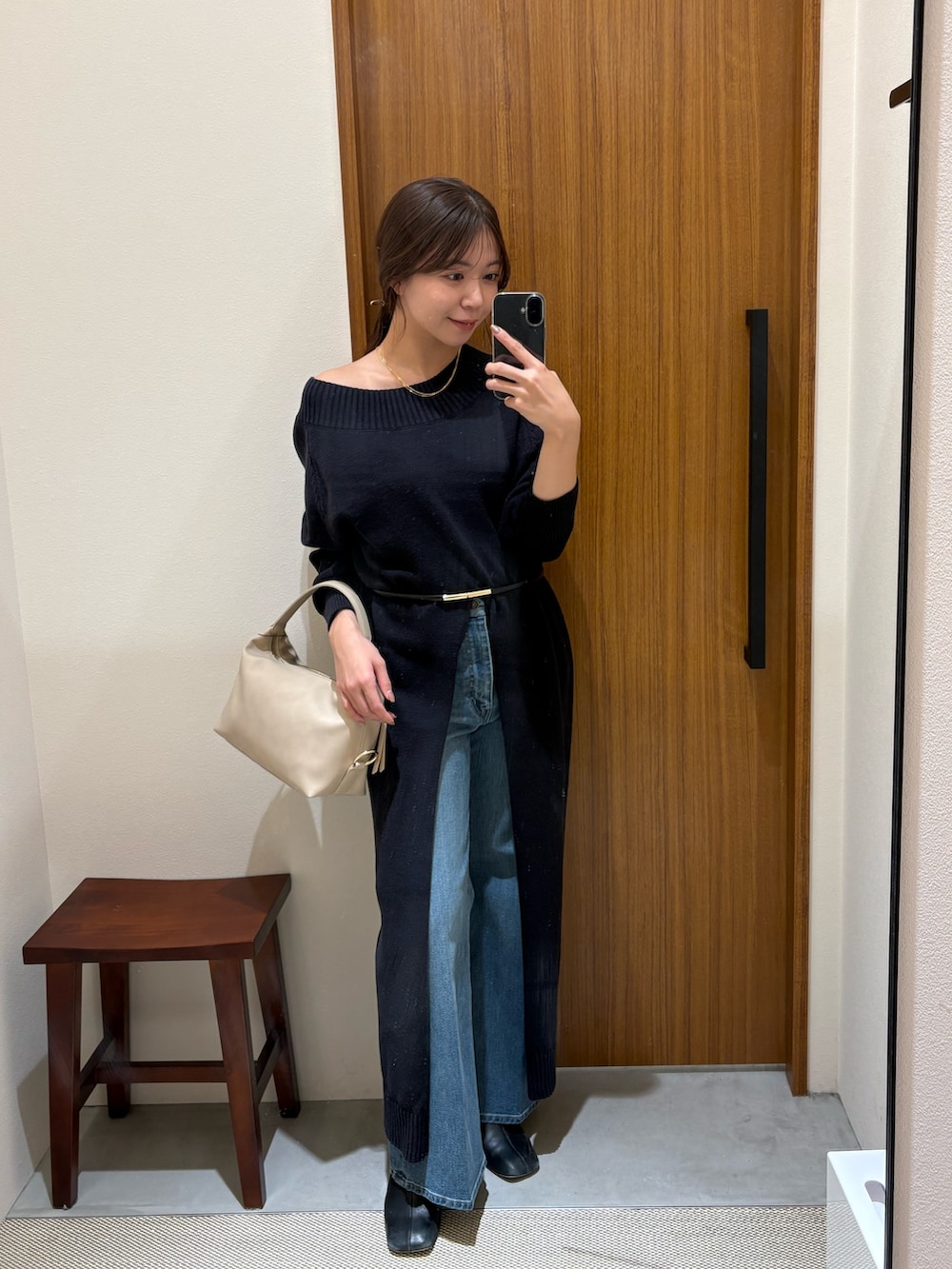 ブルー系のワンピース、ベージュ系のハンドバッグ、ブルー系のデニムパンツを着用したレディースの冬コーディネートの4枚目の写真