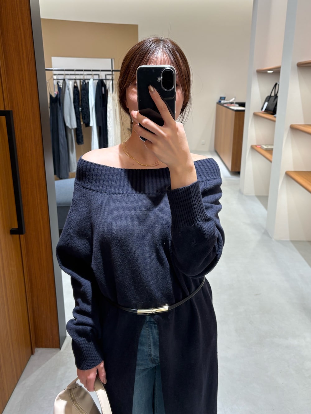 ブルー系のワンピース、ベージュ系のハンドバッグ、ブルー系のデニムパンツを着用したレディースの冬コーディネートの3枚目の写真