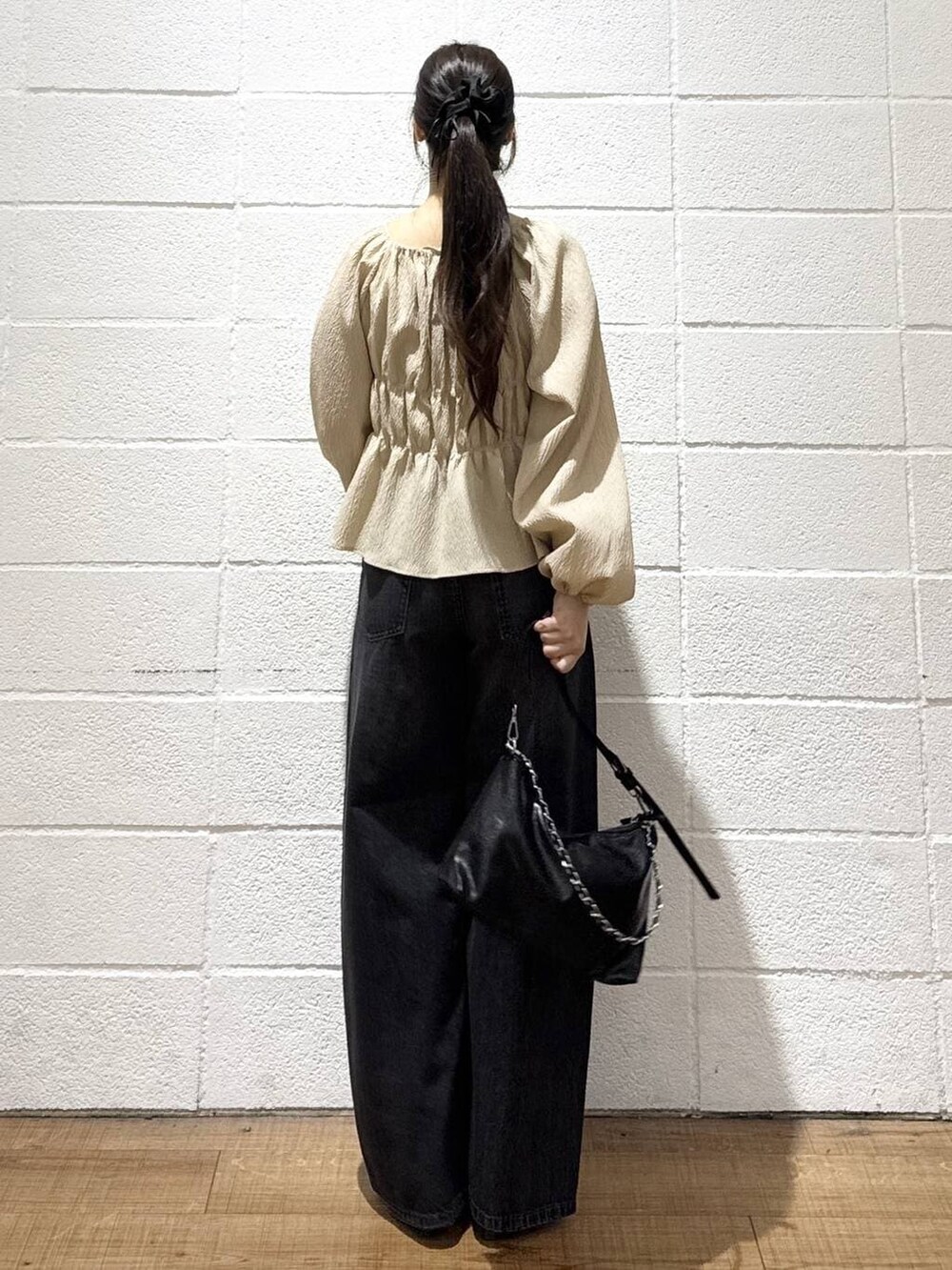 ブラック系のデニムパンツ、ブラック系のショルダーバッグ、ブラック系のサンダルを着用したレディースの春コーディネートの3枚目の写真