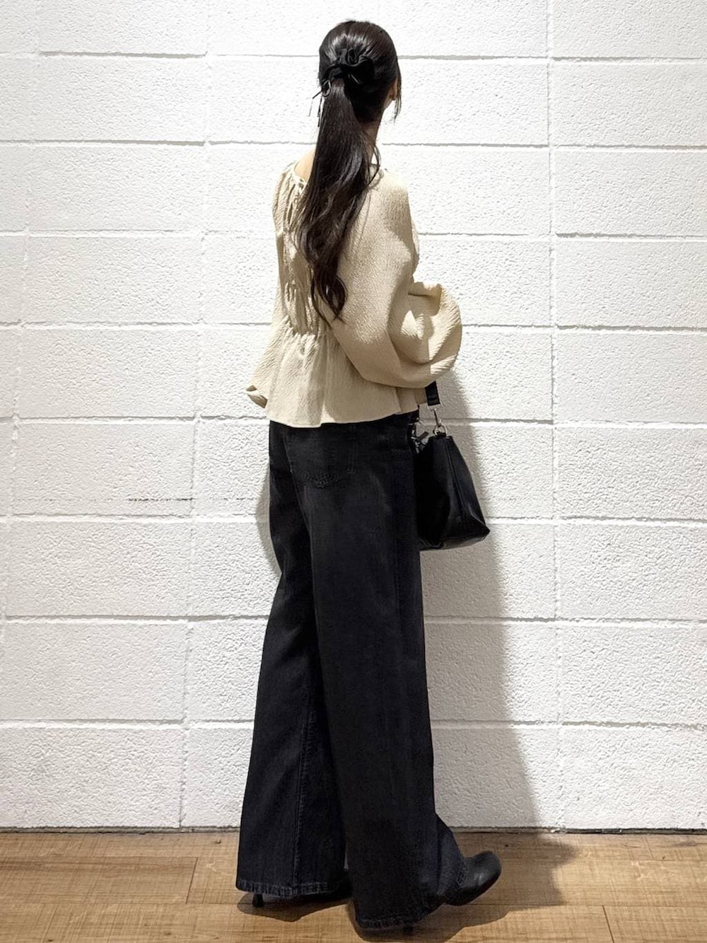 ブラック系のデニムパンツ、ブラック系のショルダーバッグ、ブラック系のサンダルを着用したレディースの春コーディネートの4枚目の写真