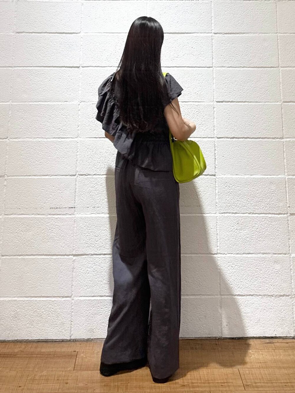 シルバー系のサンダル、グリーン系のショルダーバッグ、ブラック系のキャミソールを着用したレディースの夏コーディネートの3枚目の写真