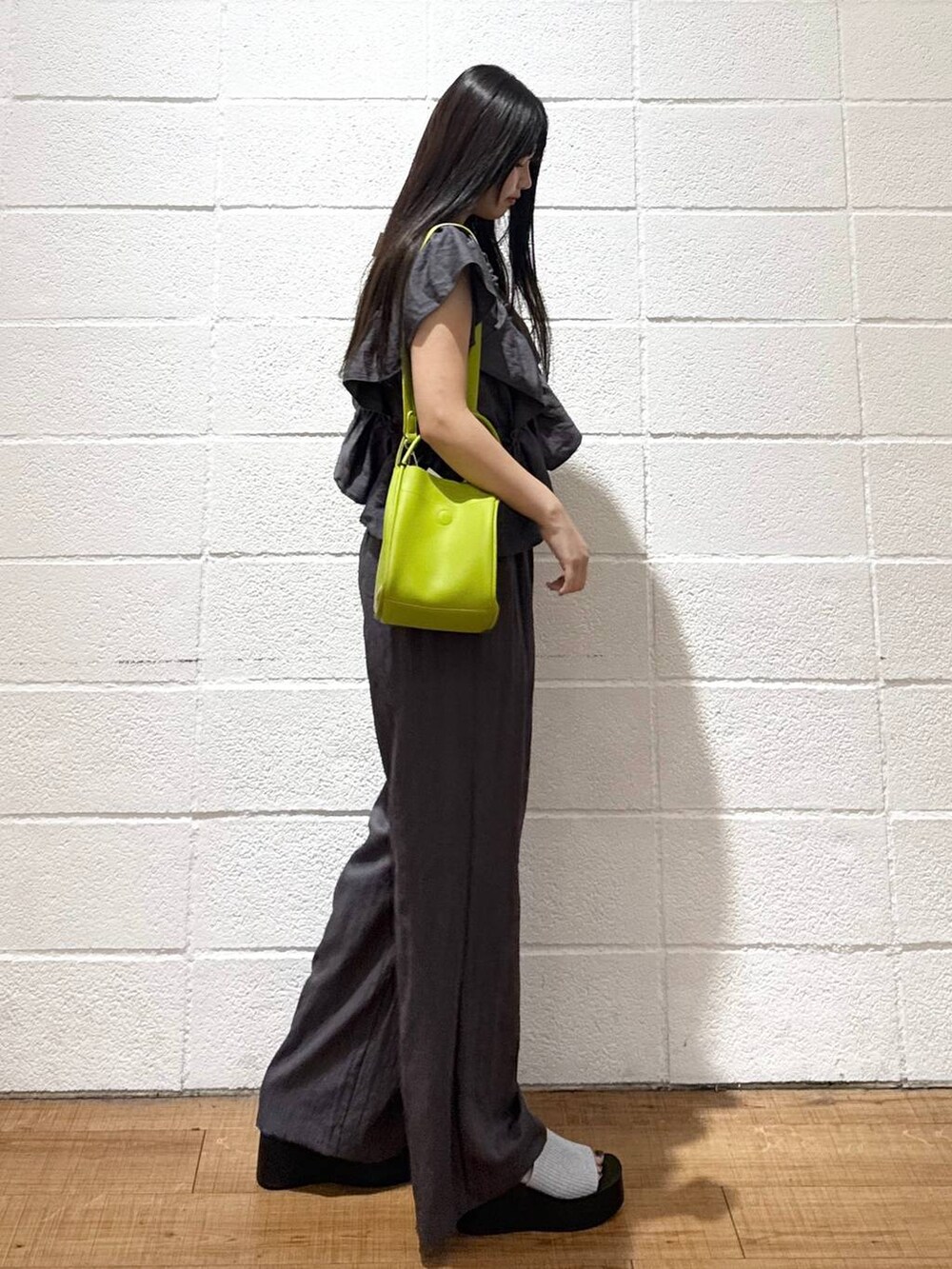 シルバー系のサンダル、グリーン系のショルダーバッグ、ブラック系のキャミソールを着用したレディースの夏コーディネートの2枚目の写真