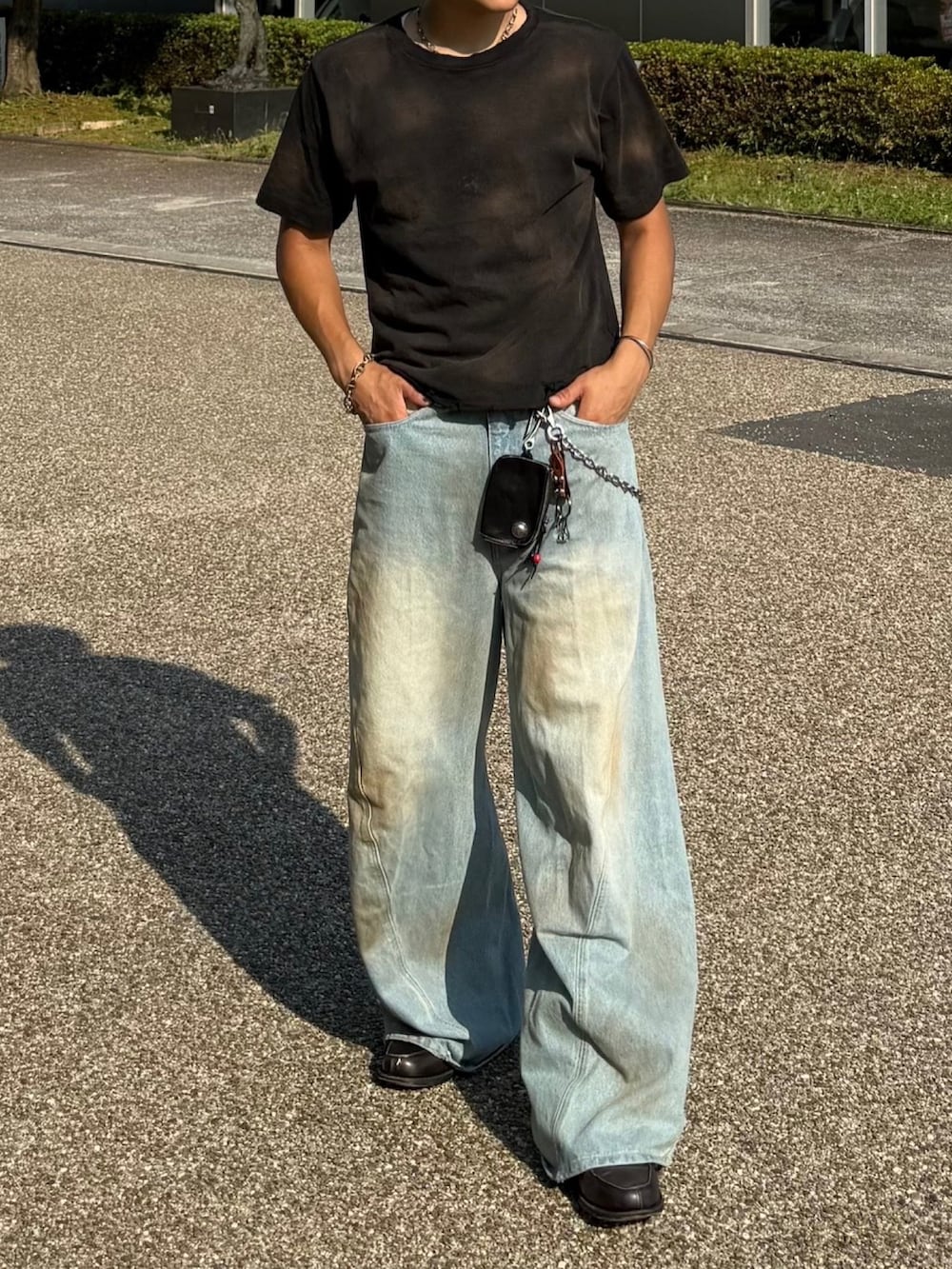 ブラック系のTシャツ/カットソー、ブルー系のデニムパンツ、グレー系のローファーを着用したメンズの夏コーディネートの2枚目の写真