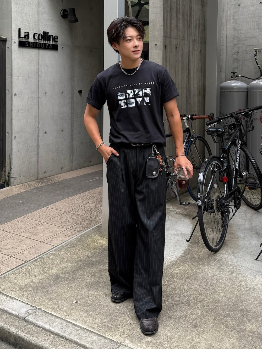 ブラック系のTシャツ/カットソー、ブラック系のスラックス、グレー系のローファーを着用したメンズの夏コーディネートの2枚目の写真