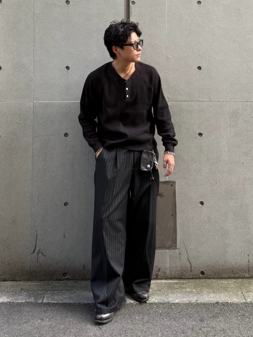 ブラック系のスラックス、ブラック系のTシャツ/カットソー、グレー系のローファーを着用したメンズの秋コーディネートの2枚目の写真