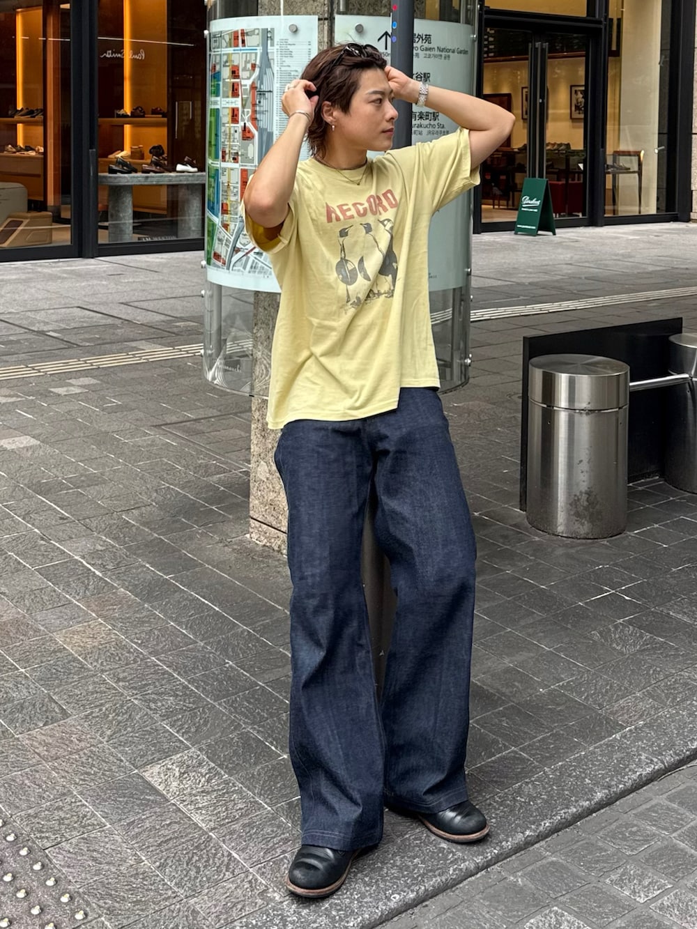 イエロー系のTシャツ/カットソー、ブラック系のデニムパンツ、ブラック系のブーツを着用したメンズの夏コーディネートの3枚目の写真