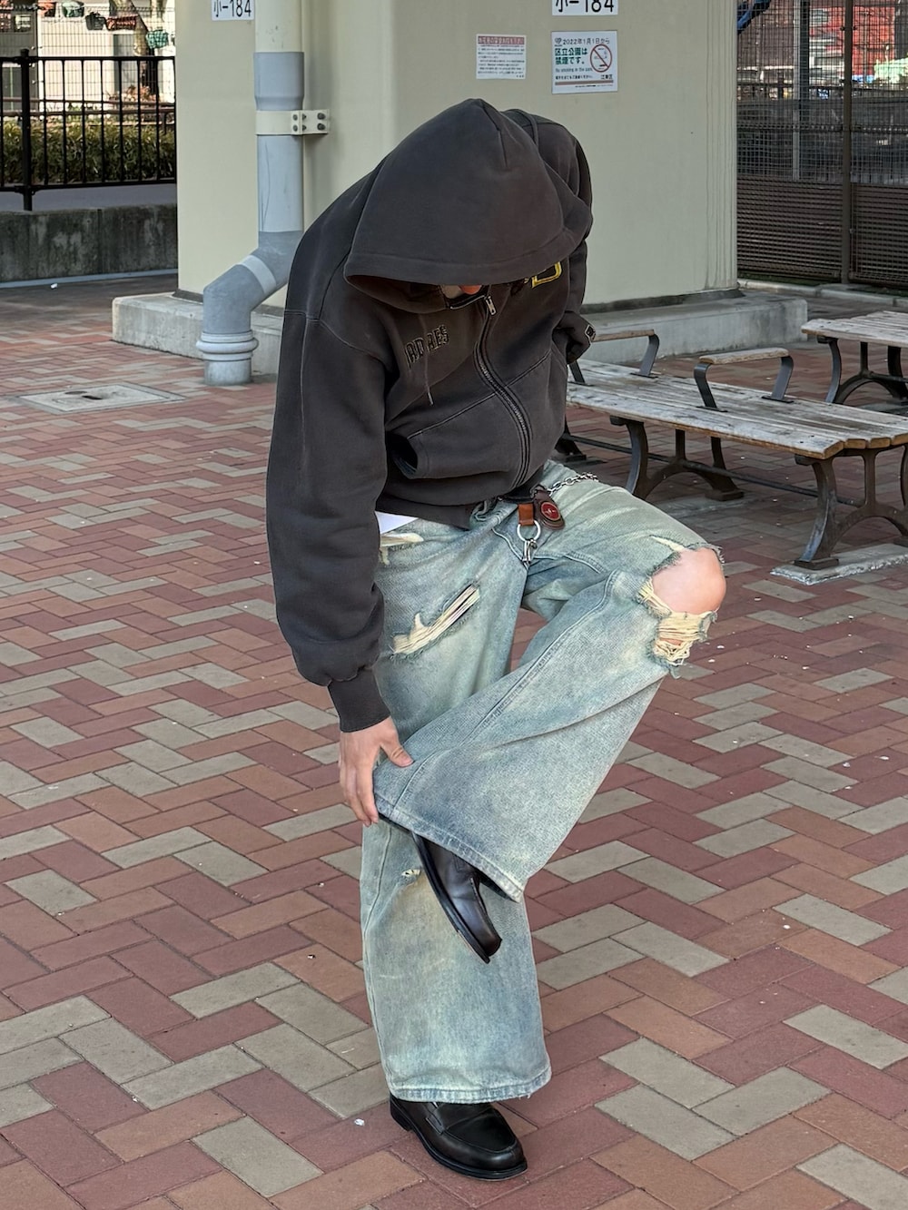 ブルー系のデニムパンツ、ブラック系のパーカー、グレー系のローファーを着用したメンズの春コーディネートの4枚目の写真