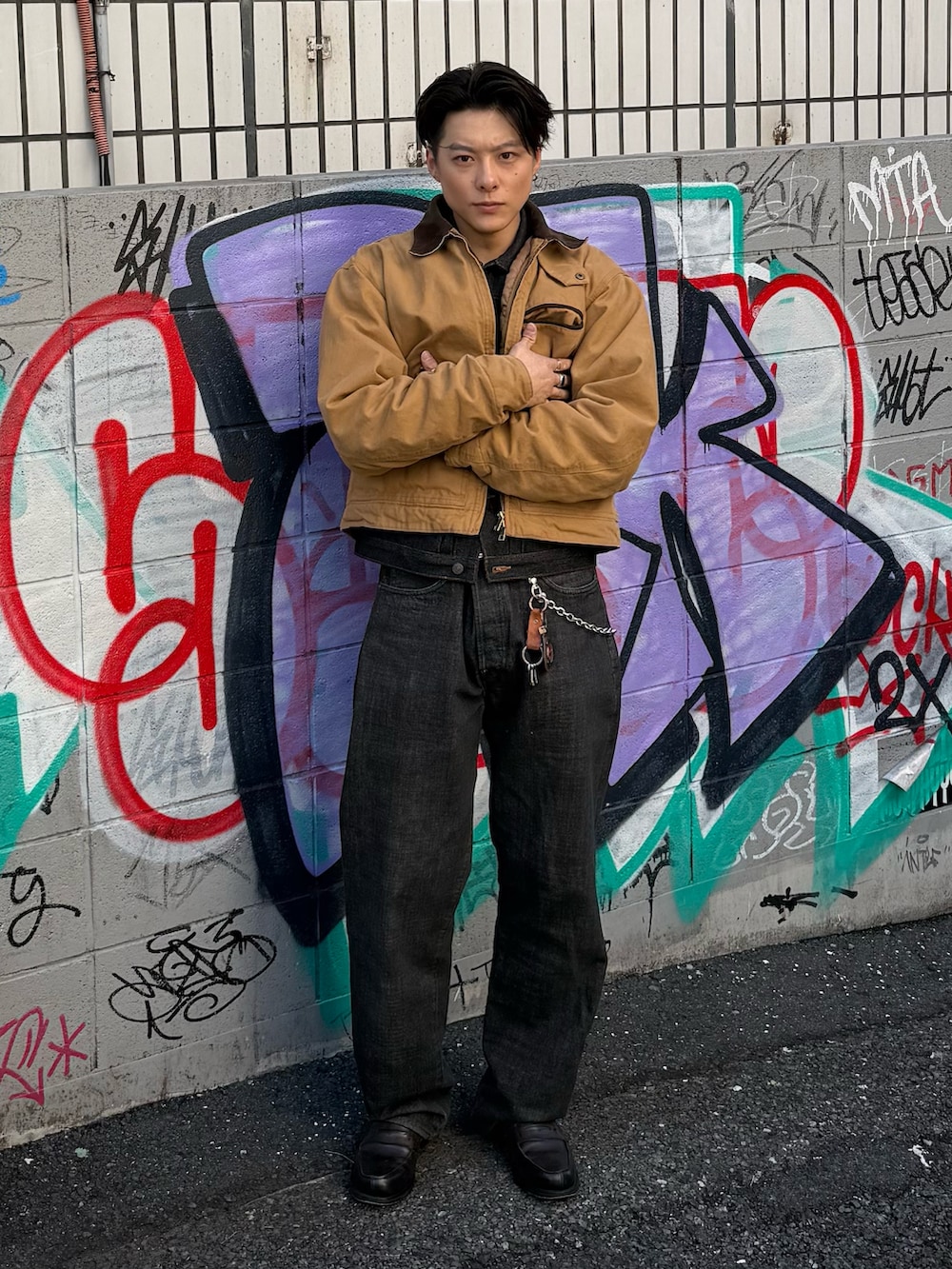 ブラウン系のブルゾン、ブラック系のデニムジャケット、ブラック系のデニムパンツを着用したメンズの春コーディネートの4枚目の写真